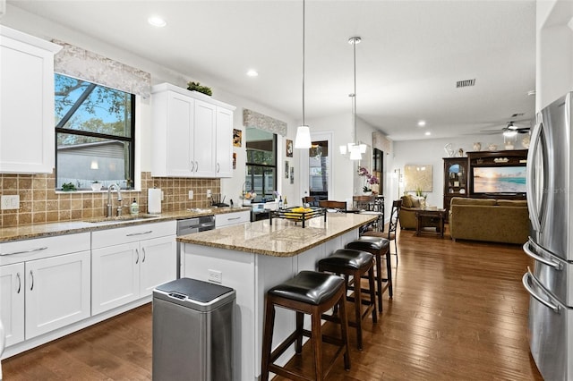 kitchen featuring backsplash, appliances with stainless steel finishes, dark wood-type flooring, and a sink