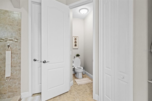 bathroom featuring baseboards, walk in shower, toilet, and tile patterned floors