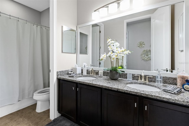 bathroom featuring tile patterned flooring, a sink, toilet, and double vanity