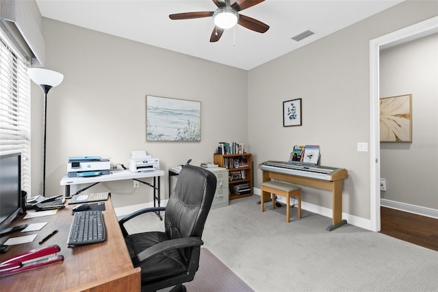 carpeted home office with baseboards, visible vents, and a ceiling fan