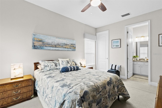 bedroom featuring light carpet, baseboards, visible vents, connected bathroom, and a ceiling fan