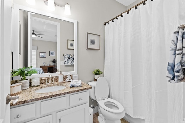 ensuite bathroom with ensuite bathroom, curtained shower, toilet, a ceiling fan, and vanity