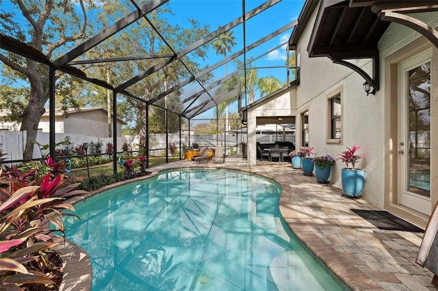 view of pool featuring a patio area, a fenced backyard, glass enclosure, and a fenced in pool