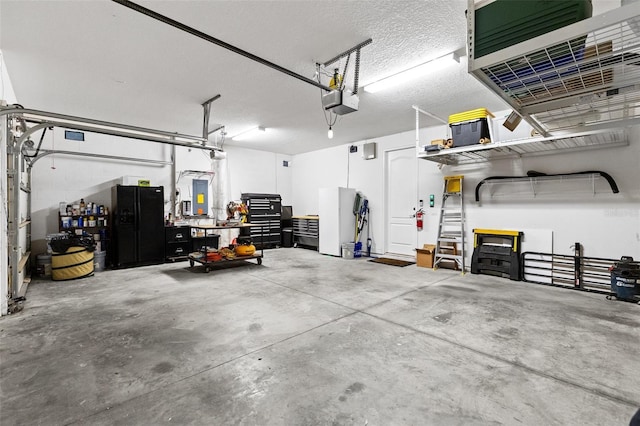 garage with a workshop area, freestanding refrigerator, and a garage door opener