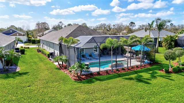 pool featuring glass enclosure, a lawn, and a patio