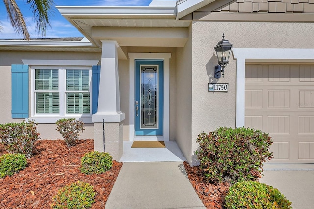 property entrance with a garage and stucco siding