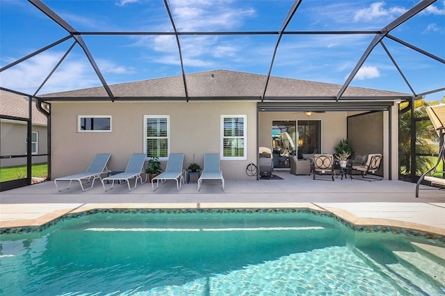 back of house with roof with shingles, a patio, stucco siding, a lanai, and an outdoor pool