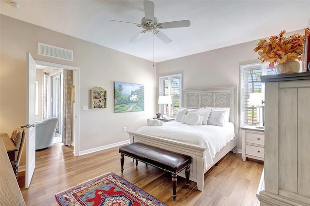 bedroom featuring light wood finished floors, baseboards, multiple windows, and visible vents