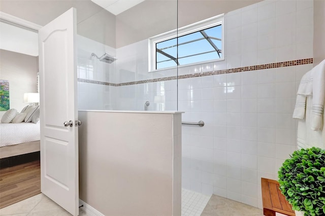 ensuite bathroom with walk in shower, tile patterned flooring, and connected bathroom