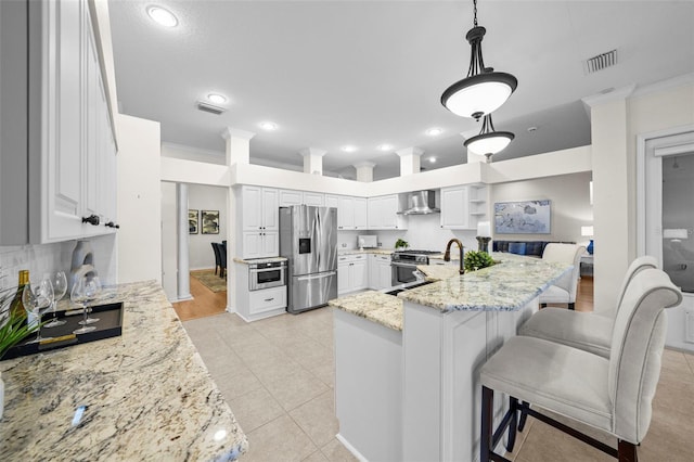 11815 Marblehead Dr, Tampa, FL 33626 - kitchen with wall chimney range hood, crown molding, appliances with stainless steel finishes, and light stone counters