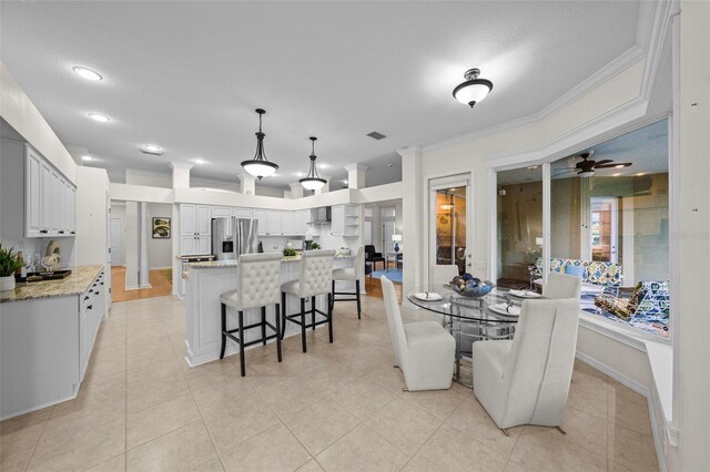 11815 Marblehead Dr, Tampa, FL 33626 - dining area with crown molding, light tile patterned floors, baseboards, visible vents, and ceiling fan