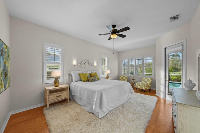 11815 Marblehead Dr, Tampa, FL 33626 - bedroom featuring access to exterior, visible vents, multiple windows, and wood finished floors