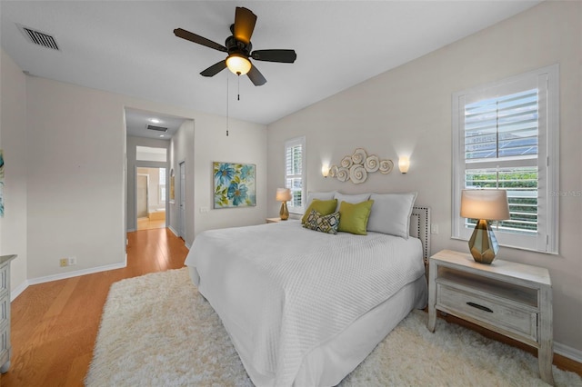11815 Marblehead Dr, Tampa, FL 33626 - bedroom with baseboards, ensuite bath, visible vents, and light wood-style floors