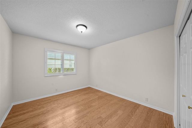 11815 Marblehead Dr, Tampa, FL 33626 - unfurnished room featuring baseboards, light wood-style flooring, and a textured ceiling