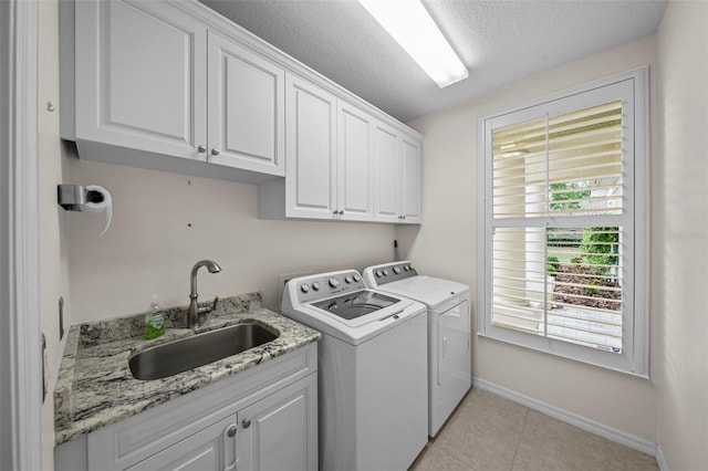 11815 Marblehead Dr, Tampa, FL 33626 - laundry room with washer and clothes dryer, a sink, a textured ceiling, baseboards, and cabinet space