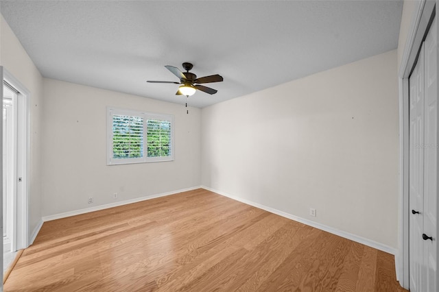 11815 Marblehead Dr, Tampa, FL 33626 - unfurnished bedroom with baseboards, a closet, light wood-style floors, and a ceiling fan