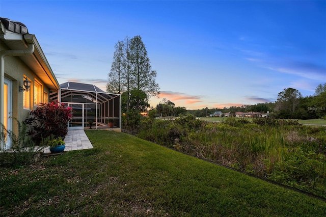 11815 Marblehead Dr, Tampa, FL 33626 - yard at dusk featuring glass enclosure and a patio area