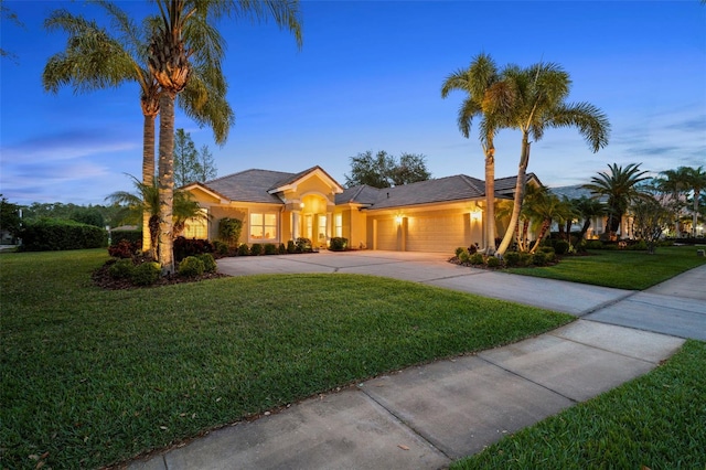 11815 Marblehead Dr, Tampa, FL 33626 - view of front facade featuring stucco siding, a garage, concrete driveway, and a yard