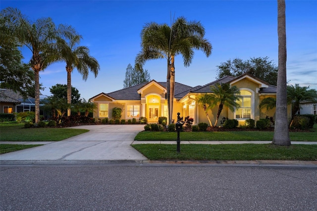 11815 Marblehead Dr, Tampa, FL 33626 - view of front of home featuring a front lawn, driveway, stucco siding, and a tiled roof