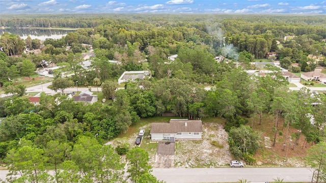 birds eye view of property featuring a forest view and a water view