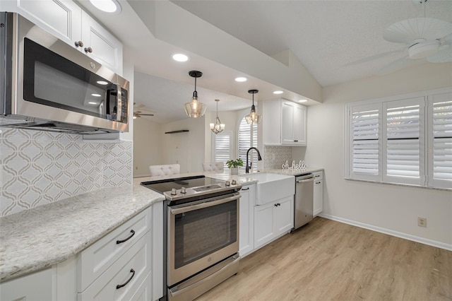 kitchen with ceiling fan, lofted ceiling, white cabinetry, appliances with stainless steel finishes, and tasteful backsplash