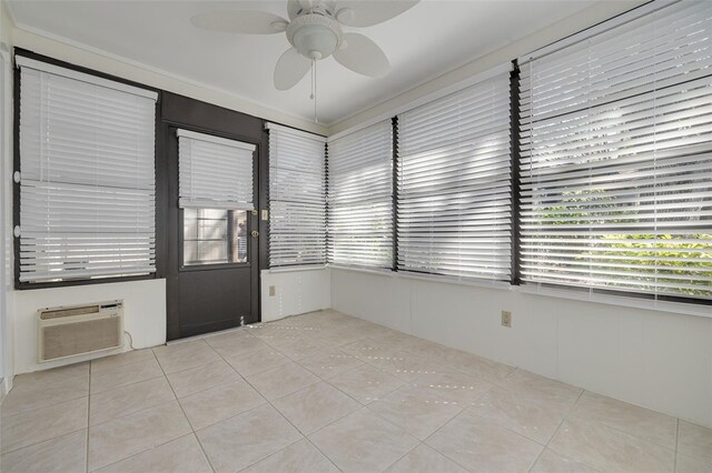 tiled spare room featuring a ceiling fan, a sunroom, and a wall mounted air conditioner