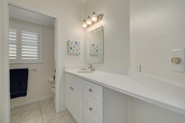 bathroom featuring toilet, tile patterned flooring, baseboards, and vanity