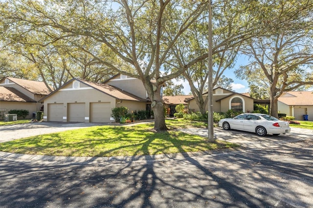 view of front of home featuring a garage, driveway, a front yard, and stucco siding