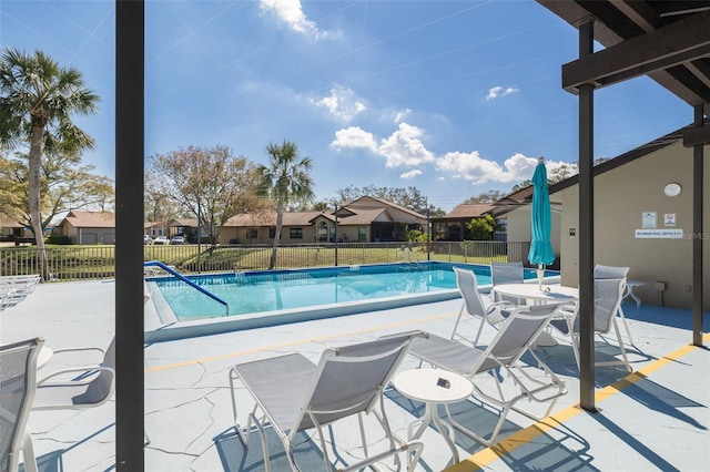 pool featuring a residential view, a patio area, and fence