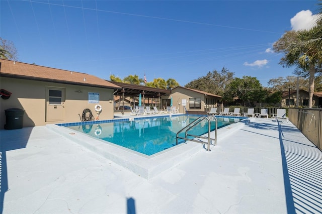 pool with a patio area and fence