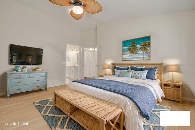 bedroom with ensuite bath, wood finished floors, a ceiling fan, and baseboards