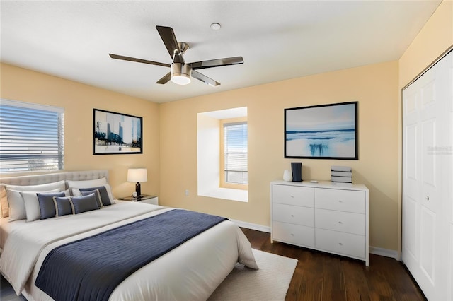 bedroom featuring baseboards, dark wood finished floors, and a ceiling fan