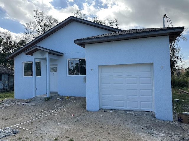 exterior space with an attached garage and stucco siding