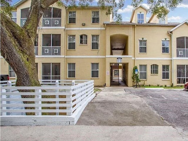 townhome / multi-family property featuring fence and stucco siding