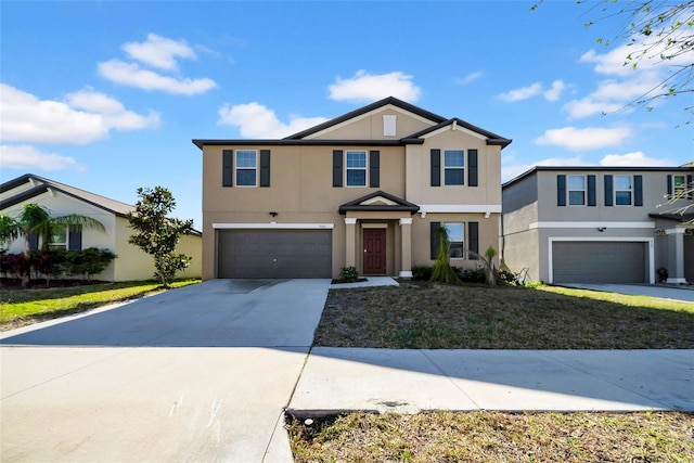 view of front of home with driveway, an attached garage, a front lawn, and stucco siding