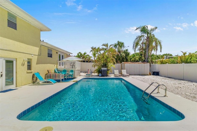 view of swimming pool featuring a patio area, a fenced backyard, and a fenced in pool