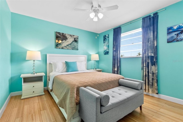 bedroom featuring wood finished floors, baseboards, and a ceiling fan