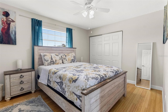 bedroom featuring wood finished floors, a closet, baseboards, and ceiling fan