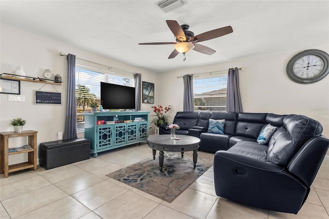 tiled living area featuring ceiling fan, a wealth of natural light, and visible vents