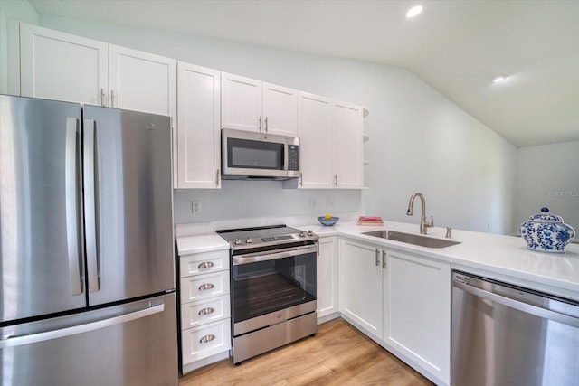 kitchen with stainless steel appliances, light countertops, white cabinetry, open shelves, and a sink