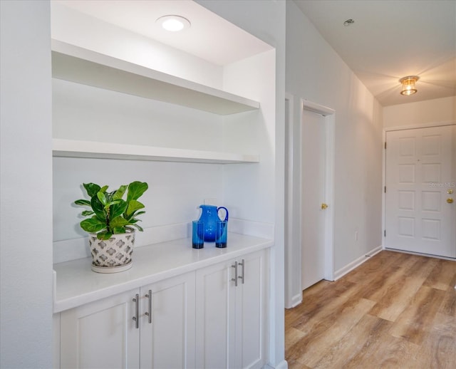 foyer entrance with light wood-style flooring and baseboards