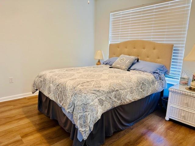 bedroom featuring baseboards and wood finished floors