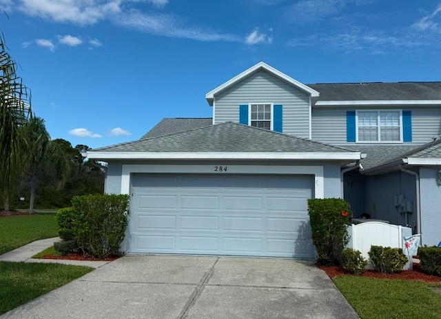 view of front of property with a garage, concrete driveway, and roof with shingles