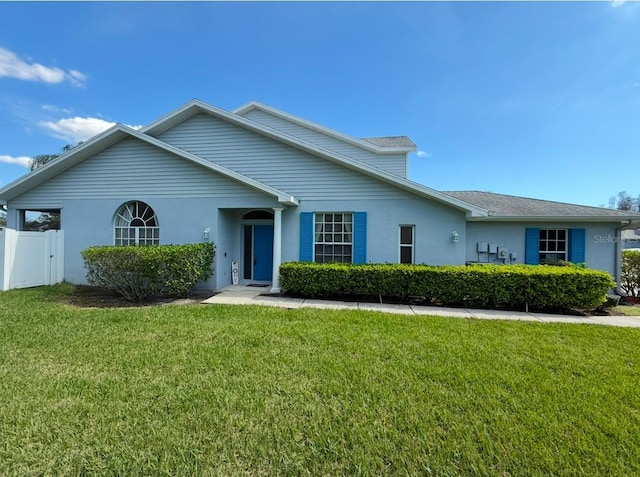 ranch-style home with a front lawn, fence, and stucco siding