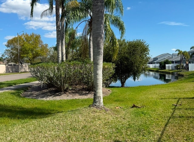 view of yard featuring a water view and fence