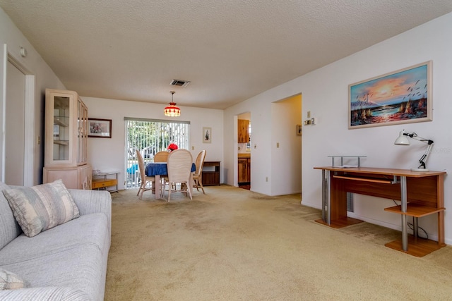 living room with light colored carpet, visible vents, and a textured ceiling