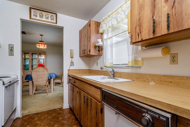 kitchen featuring white electric range, light countertops, a sink, and decorative light fixtures