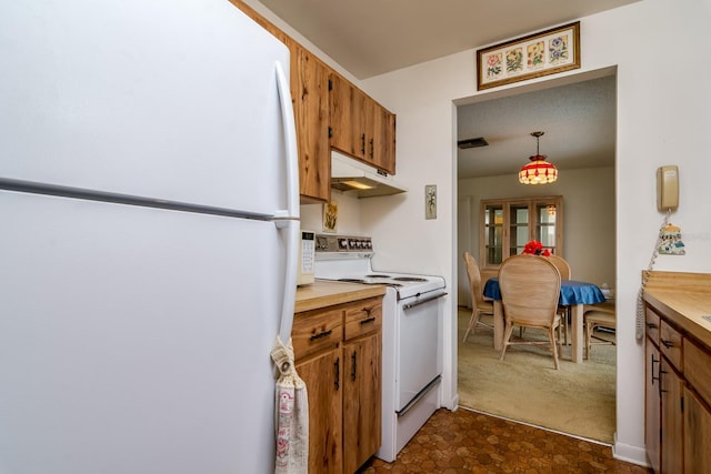 kitchen featuring brown cabinets, decorative light fixtures, light countertops, white appliances, and under cabinet range hood