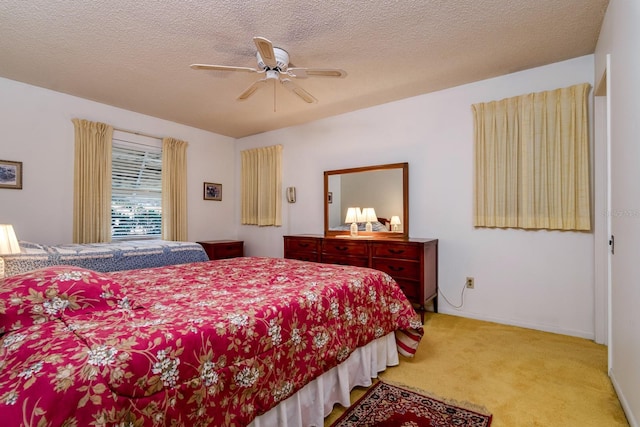 carpeted bedroom with a ceiling fan, baseboards, and a textured ceiling