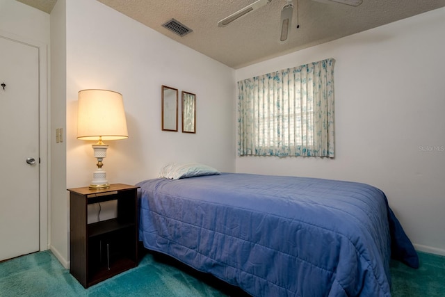 bedroom featuring a ceiling fan, carpet, visible vents, and a textured ceiling